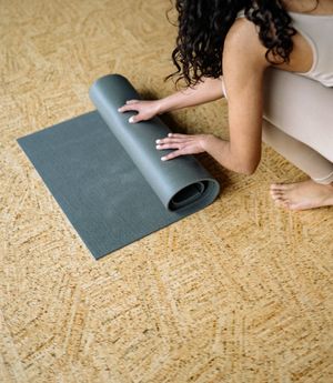 Yoga mat rolled out on a wooden floor.